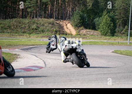 Moto pratica inclinandosi in una curva veloce in pista. Foto Stock