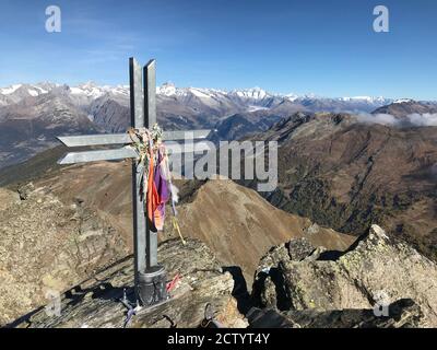 Vista dalla cima dell'Ochsenhorn con la sua semplice croce in metallo sulle cime delle alpi nell'alto Vallese, Svizzera Foto Stock