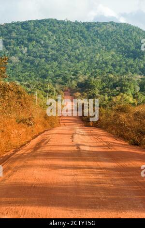 Una sezione della strada sterrata non asfaltata C106 con Shimba Hills sullo sfondo, Kenya, Africa orientale Foto Stock