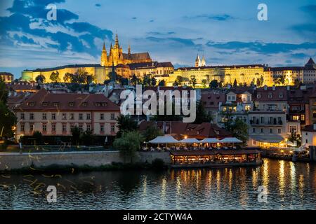 PRAGA, REPUBBLICA CECA - 18 LUGLIO 2019: Vista del Castello di Praga e della Cattedrale di San Vito illuminata di notte visto attraverso il fiume Moldava Foto Stock