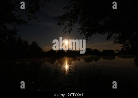 sopra un lago le stelle e la luna possono essere visto nel cielo notturno Foto Stock