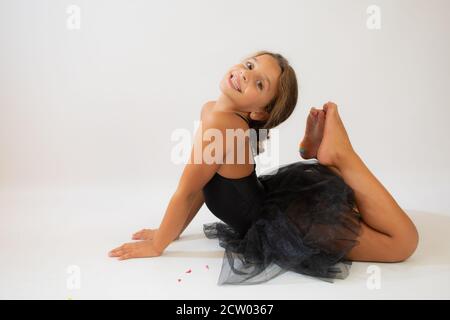 Piccola ballerina in spaccato sul pavimento, spazio di copia. Sorridente bambina sognando di diventare ballerina professionale, scuola di danza classica Foto Stock