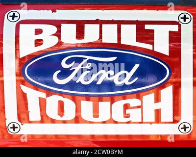 Segnaletica dipinta di un marchio Ford auto Company logo su sfondo rosso, Ford costruito duro, mostrando il supporto per la qualità dei veicoli, visto in Asia Foto Stock