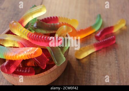Halloween gummy vermi in una ciotola. Caramelle colorate a forma di vermi di gelatina. Foto Stock