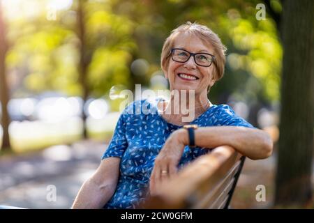 Donna anziana felice godendo una giornata all'aperto Foto Stock