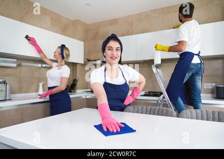 Servizio di pulizia squadra al lavoro in cucina in casa privata Foto Stock