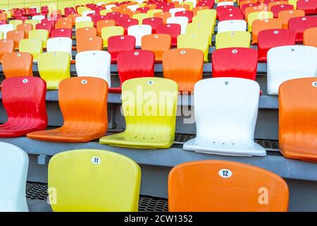 Sedili colorati dello stadio in fila - vista laterale Foto Stock