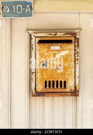 Scatola di posta arrugginita in metallo sulla porta di legno Foto Stock