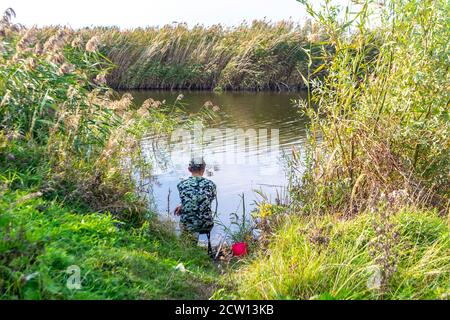 Pescatore al lago nella soleggiata giornata estiva Foto Stock
