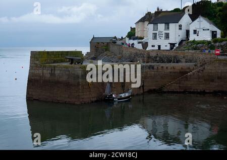 Vista che mostra la parete del porto, cannone e nave Inn, città e porto di pesca di Porthleven, Cornovaglia Foto Stock