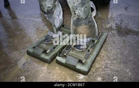 18 dicembre 1995 durante la guerra in Bosnia: Scarpe gonfiabili (pneumatiche) di sminamento, indossate da un soldato francese che conduce lo sminamento intorno alla pista all'aeroporto di Mostar. Foto Stock