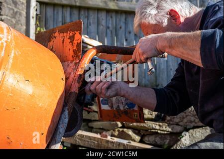 Cinghia del miscelatore per cerment di fissaggio maschio senior impostando la tensione di cinghia per evitare lo slittamento Foto Stock