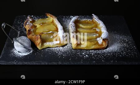 Crostata di mele con zucchero a velo su fondo scuro. Foto Stock