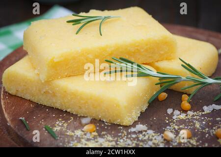 Fette di polenta di mais su tavola di legno. Palenta fatta in casa, cibo vegetariano sano. Foto Stock