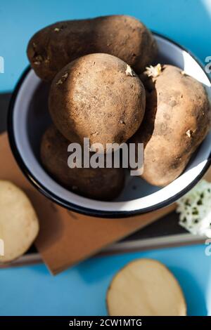 patate rosse non lavate in una ciotola in tutto e in sezione Foto Stock