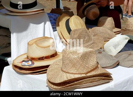 Una bancarella di mercato con cappelli di paglia. I prodotti vengono impilati per risparmiare spazio. Foto Stock