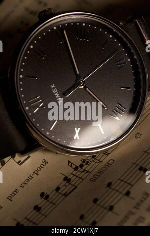 Orologio da polso analogico Timex con musica da spartiti. Cinturino in pelle nera con numeri romani in argento. Foto Stock