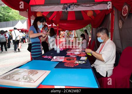 Kuala Lumpur, Malesia. 26 Settembre 2020. Una donna sperimenta il taglio della carta durante la campagna Cina-Malesia Cultura e Turismo - Divertimento con la natura a Kuala Lumpur, Malesia, 26 settembre 2020. La campagna Cina-Malesia Cultura e Turismo Month-Fun with Nature è iniziata sabato allo Zoo Nazionale della Malesia, attirando oltre 1,000 visitatori il primo giorno. Credit: Zhu Wei/Xinhua/Alamy Live News Foto Stock