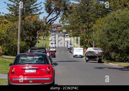 Tipica scena di Sydney Street nell'area residenziale di Avalon Beach auto e barca parcheggiate, inclusa mini auto rossa Foto Stock