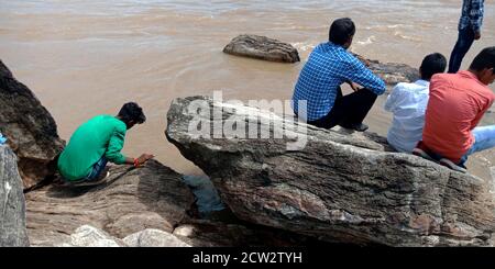 CITTÀ JABALPUR, INDIA - 18 AGOSTO 2019: La gente del villaggio indiano che siede alla banca del fiume di Narmada in Bhedaghat intorno alla cascata di Dhuandhar. Foto Stock