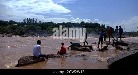 CITTÀ JABALPUR, INDIA - 18 AGOSTO 2019: La gente del villaggio indiano che siede alla banca del fiume di Narmada in Bhedaghat intorno alla cascata di Dhuandhar. Foto Stock