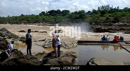 CITTÀ DI JABALPUR, INDIA - 18 AGOSTO 2019: La gente indiana sta in piedi un rischio al fiume Narmada in Bhedaghat intorno alla cascata di Dhuandhar. Foto Stock