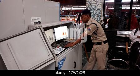 DISTRETTO DI JABALPUR, INDIA - 07 AGOSTO 2019: Un ufficiale della polizia ferroviaria indiana RPF che controlla i bagagli dei passeggeri sullo schermo del monitor al cancello di entrata. Foto Stock