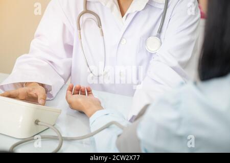 Infermiere che prende la pressione sanguigna del paziente ospizio Foto Stock