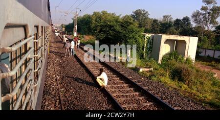 DISTRETTO KATNI, INDIA - 17 AGOSTO 2019: Gli Indiani seduti sulla pista ferroviaria a sfondo aperto. Foto Stock