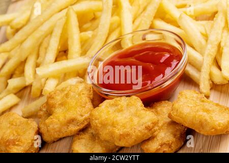 Primo piano di deliziosi pepite di pollo e patatine fritte con ketchup Foto Stock
