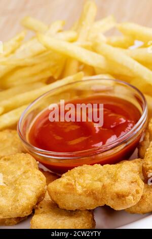 Primo piano di deliziosi pepite di pollo e patatine fritte con ketchup Foto Stock