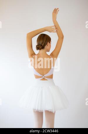 Giovane e incredibilmente bella ballerina è in posa e balli in un studio bianco pieno di luce. Foto grandemente riflette la bellezza incomparabile di Foto Stock
