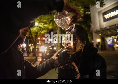 Portland, OREGON, Stati Uniti. 27 Settembre 2020. Un protester ha i loro occhi sciacquati con acqua dopo essere stato spruzzato pepe a Portland, Oregon, Stati Uniti 26 settembre 2020. Portland ha subito una protesta ogni notte dalla morte di George Floyd. La protesta di questa notte ha coinciso con un orgoglioso Boys rally all'inizio della giornata. Credit: Stephanie Keith/ZUMA Wire/Alamy Live News Foto Stock