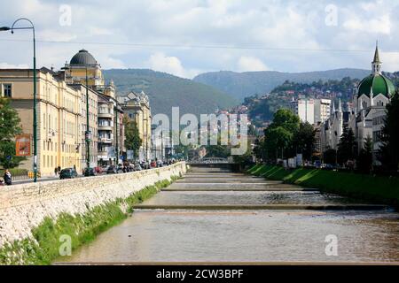 Via Obala Kulina Bana corre lungo le rive del fiume Miljacka ed è uno dei punti di riferimento di Sarajevo. Foto Stock