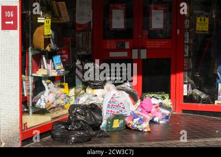 Pontypridd, Galles - Settembre 2020: Borse di merci donate lasciate fuori dalla porta di un negozio di beneficenza a Pontypridd. Foto Stock