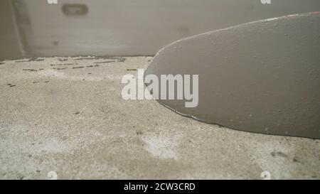 Versare il pavimento liquido sulla superficie in calcestruzzo. Livellare il pavimento con una Malta autolivellante. Livellare il pavimento con una Malta autolivellante. Foto Stock