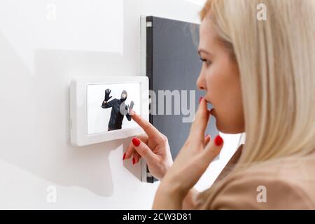 Donna dentro casa interfono risposta Foto stock - Alamy