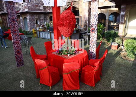 Jodhpur, Rajasthan, India, 20 agosto 2020: Tavolo rosso organizzato e sedie con fiori pronti per gli ospiti seduti in cortile o prato, decorato Foto Stock