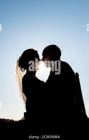 Sposa e Groom che si affacciano l'uno verso l'altro in Silhouette Foto Stock
