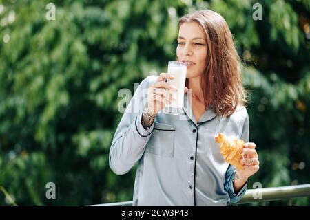 Donna con la colazione sul balcone Foto Stock