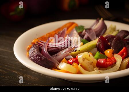 Stufate le verdure in un piatto, carote con aglio e cipolle rosse, zucchine con peperone e barbabietole, peperoni dolci e caldi e spezie Foto Stock