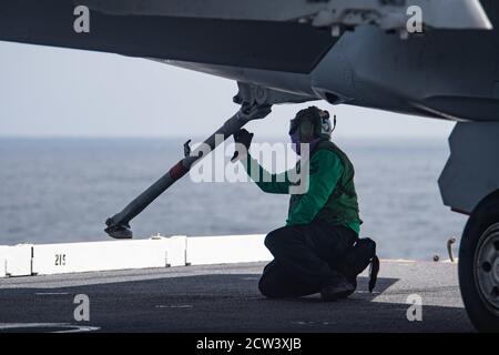 OCEANO PACIFICO (settembre 25, 2020) – U.S. Navy Aviation Electronics Technician 2nd Class Cameron Brehler, di Seattle, assegnato ai "Vikings" di Electronic Attack Squadron (VAQ) 129, ispeziona il gancio di coda di un e/A-18G Growler sul ponte di volo della portaerei USS Theodore Roosevelt (CVN 71) 25 settembre 2020. Theodore Roosevelt sta conducendo operazioni di routine nel Pacifico orientale. (STATI UNITI Fotografia marina di Seaman Dylan Lavin, specialista della comunicazione di massa) Foto Stock