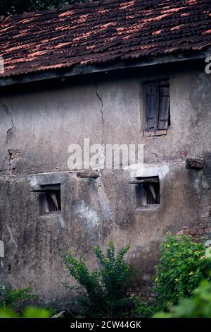 Sezione dell'esterno di una vecchia casa in un ambiente rurale in una giornata nuvolosa Foto Stock