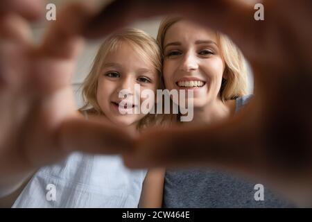 Affettuosa giovane madre e figlia affettuosa che fanno selfie Foto Stock