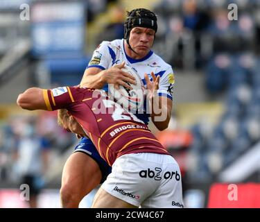 Jonny Lomax (6) di St Helens è affrontato da Sam Hewitt (26) dei Giganti di Huddersfield Foto Stock