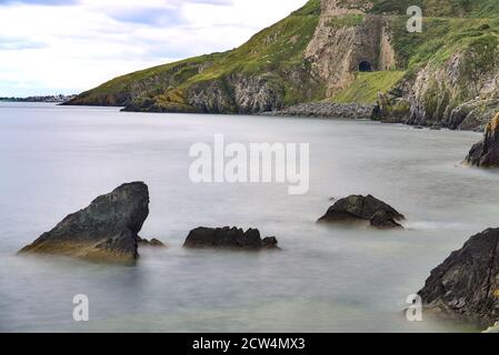 Mozzafiato Bray a Greystones Cliff Walk. Bellissimo scatto a lunga esposizione della linea costiera a Bray, Co. Wicklow, Irlanda Foto Stock