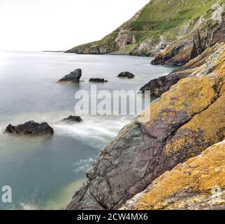 Mozzafiato Bray a Greystones Cliff Walk. Bellissimo scatto a lunga esposizione della linea costiera a Bray, Co. Wicklow, Irlanda Foto Stock