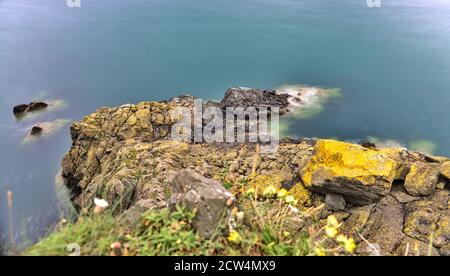 Meravigliosa stagionatura lungo la Bray a Greystones Cliff Walk. Incredibile scatto a lunga esposizione della linea costiera a Bray, Co. Wicklow, Irlanda Foto Stock