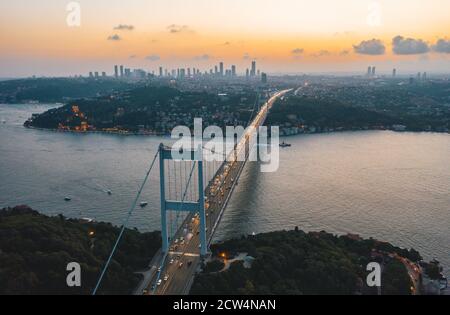 Ponte sul Bosforo di Istanbul al tramonto con semafori in auto e skyline della città, vista aerea Foto Stock