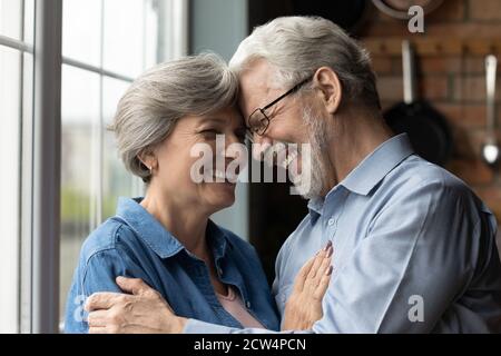 Felice abbraccio uomo maturo e donna che mostra amore e cura Foto Stock
